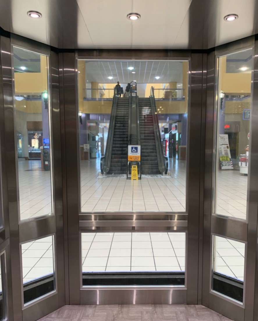 elevator cab in mall with a view of the escalators