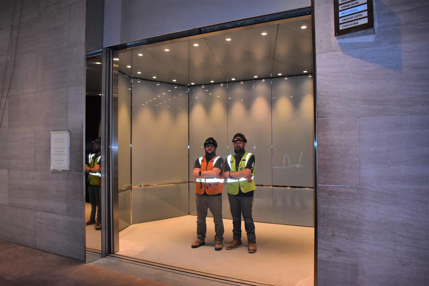 two workers in a large custom elevator