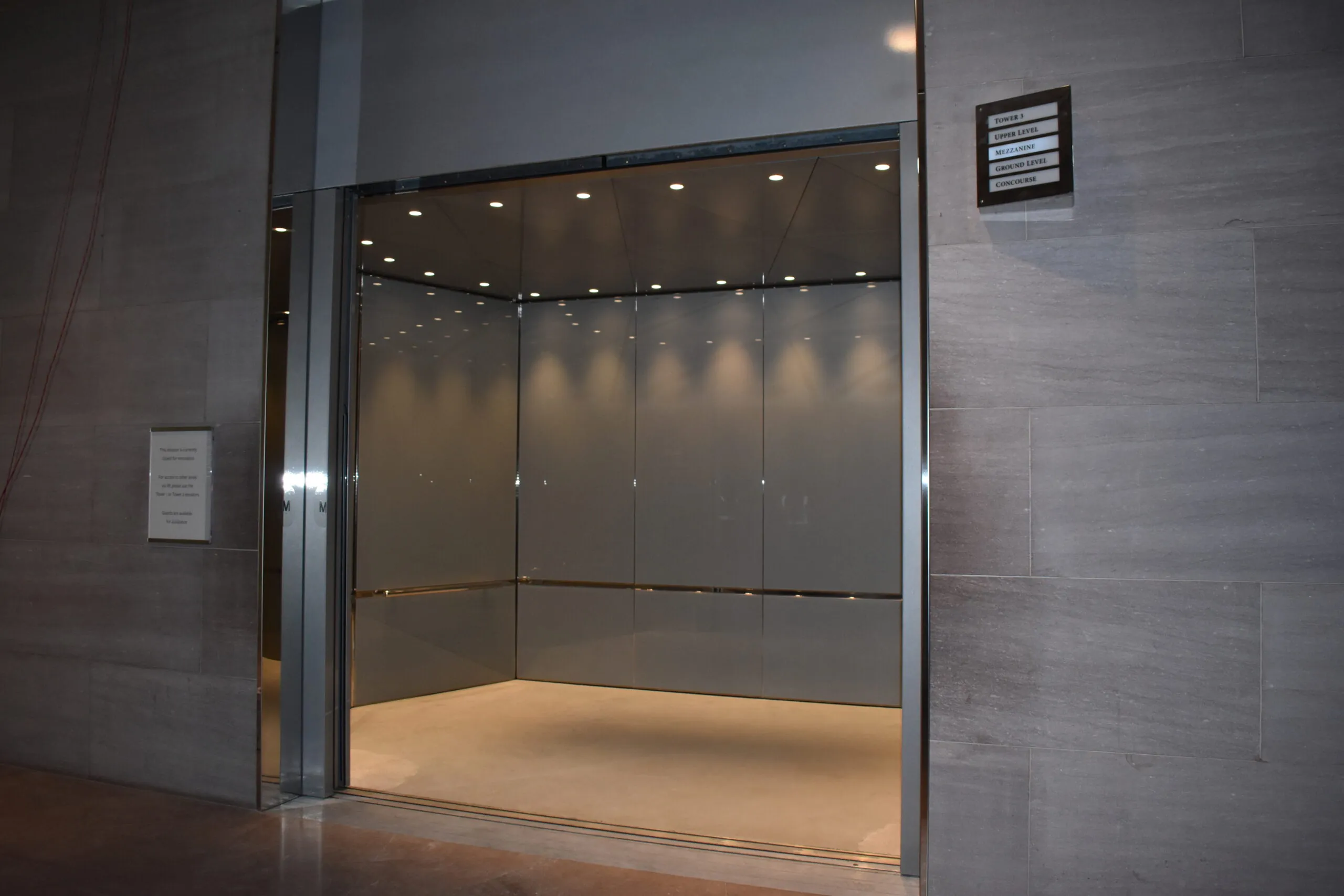 an empty room with a glass door and a sign on the wall