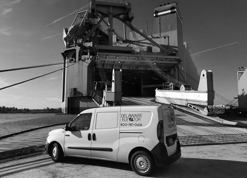 a white van parked in front of a large ship