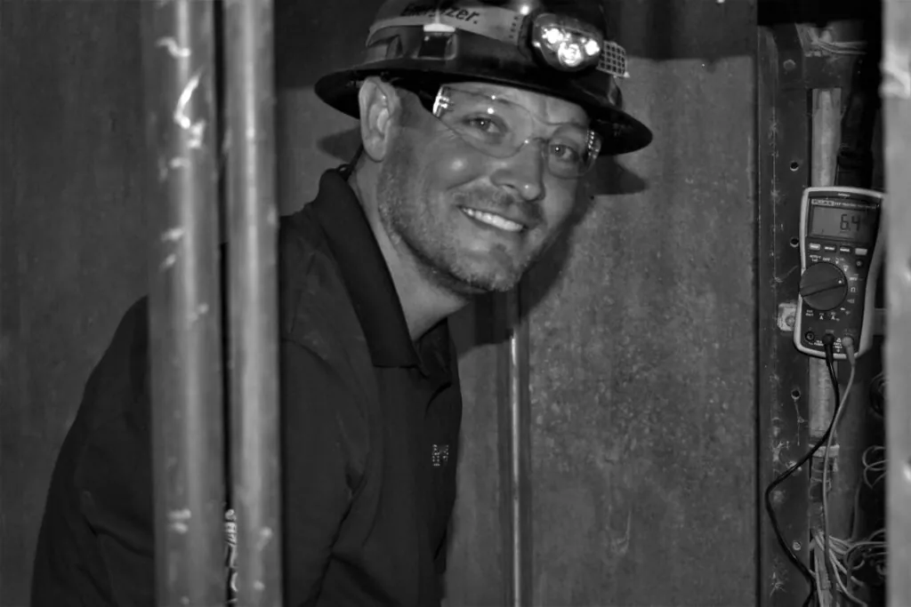 a black and white photo of a man wearing a fireman's hat