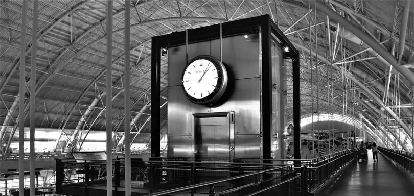 a black and white photo of a clock in a train station