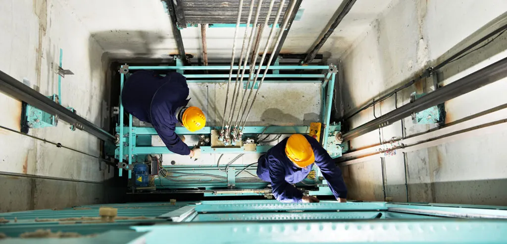 two workers working on a machine in a factory