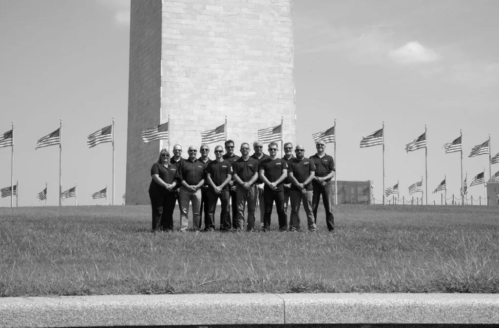 a group of men standing next to each other in front of flags