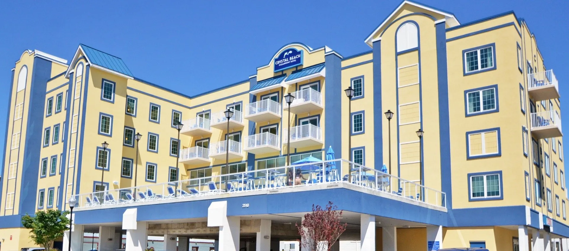 a yellow and blue hotel with a car parked in front of it