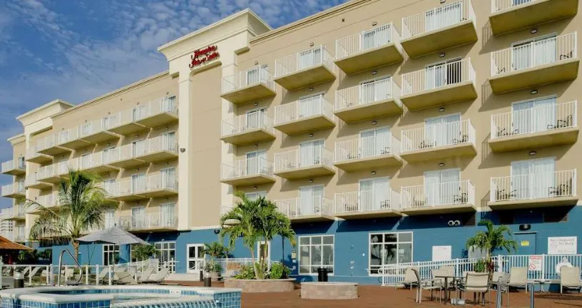 a hotel with a swimming pool in front of it