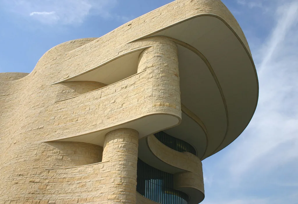 a tall building with a curved design on top of it