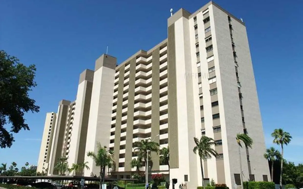 a large white building with palm trees in front of it