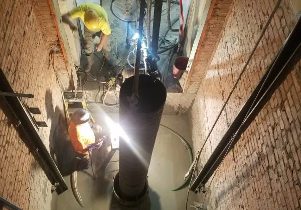 a view down a narrow alley way with a light shining on the floor